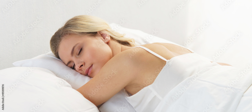 Young and beautiful blond girl in the bed. Sleeping woman in a rays of morning sun. Young and beautiful blond girl in the bed. Sleeping woman in a rays of morning sun.