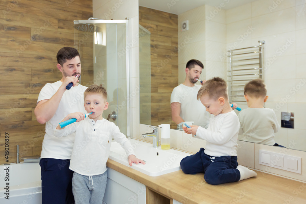Fototapeta premium Father and young son brush their teeth in the morning, have fun together