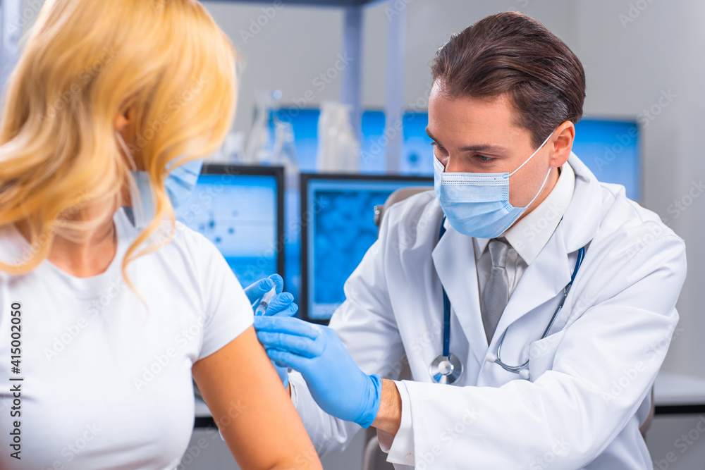 Professional doctor makes a coronavirus vaccine using a syringe and hypodermic needle. Professional medical worker and patient at the hospital office. Vaccination and safety. Professional doctor makes a coronavirus vaccine using a syringe and hypodermic needle. Professional medical worker and patient at the hospital office. Vaccination and safety.