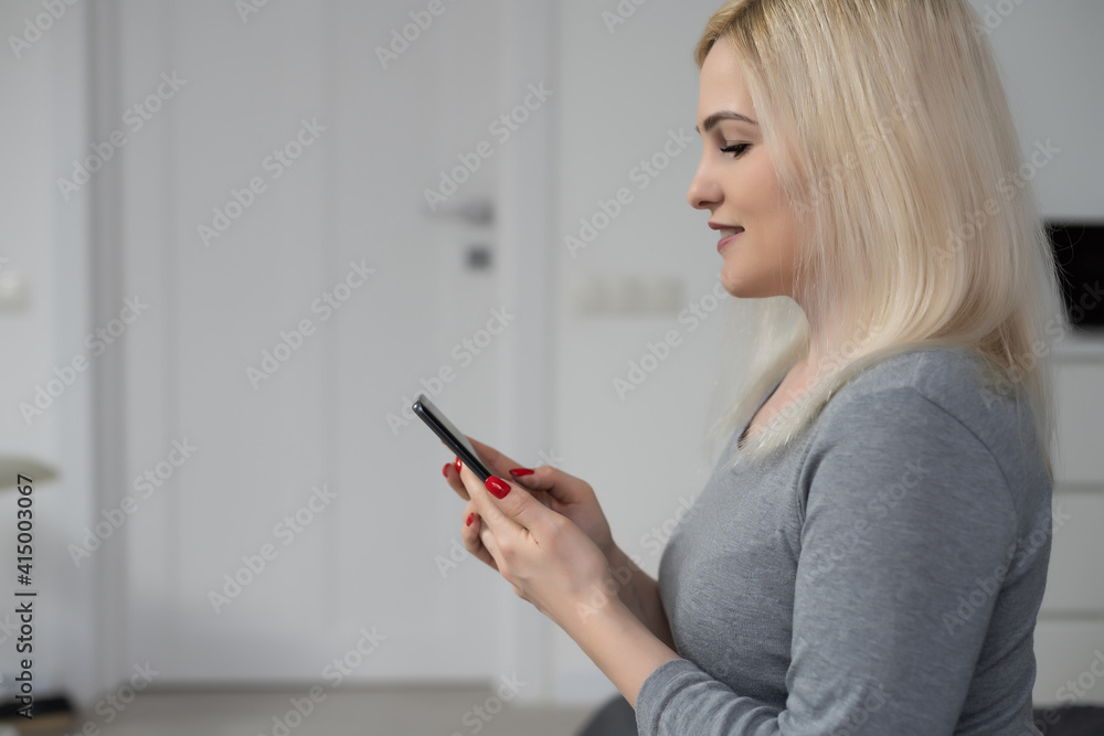 Happy woman using smartphone on the bed at home Happy woman using smartphone on the bed at home