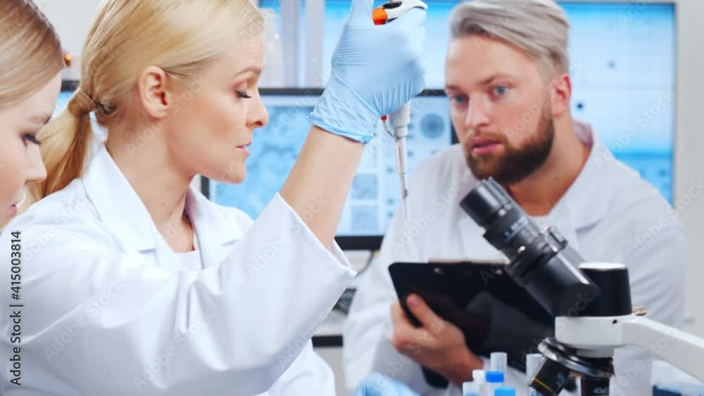 Professional team of scientists is working on a vaccine in a modern scientific research laboratory. Genetic engineer workplace. Future technology and science. Professional team of scientists is working on a vaccine in a modern scientific research laboratory. Genetic engineer workplace. Future technology and science.