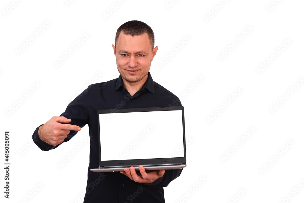 Smiling man pointing his finger at a blank laptop computer screen. isolated on a white background. A calm, unemotional smile. Smiling man pointing his finger at a blank laptop computer screen. isolated on a white background. A calm, unemotional smile.