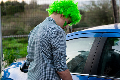 boy getting into a car wearing a green wig