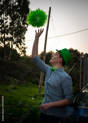 boy in green cap throwing a wig in the air on St. Patrick's Day