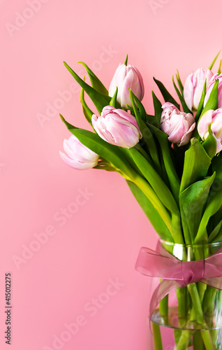 Spring. A bunch of pink tulips in a vase with space for text.Vertical © piksik