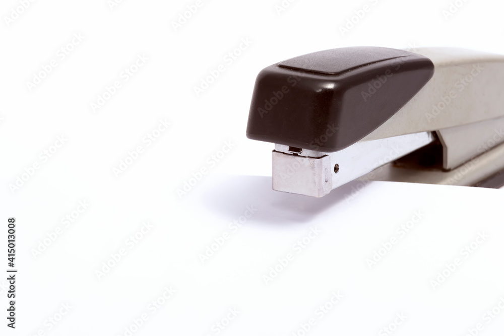Black stapler with sheet of paper on white background Black stapler with sheet of paper on white background