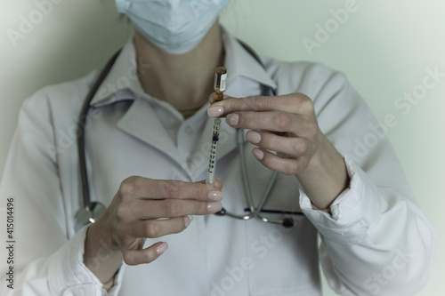 Female doctor with a stethoscope on shoulder holding syringe and vaccine. Healthcare And Medical concept.