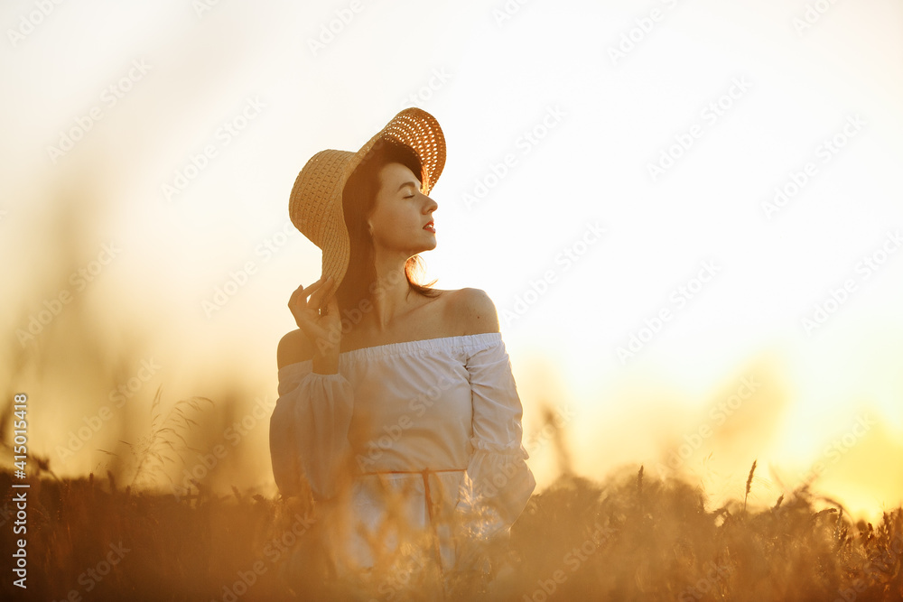 girl in the rays of the setting sun in a wheat field