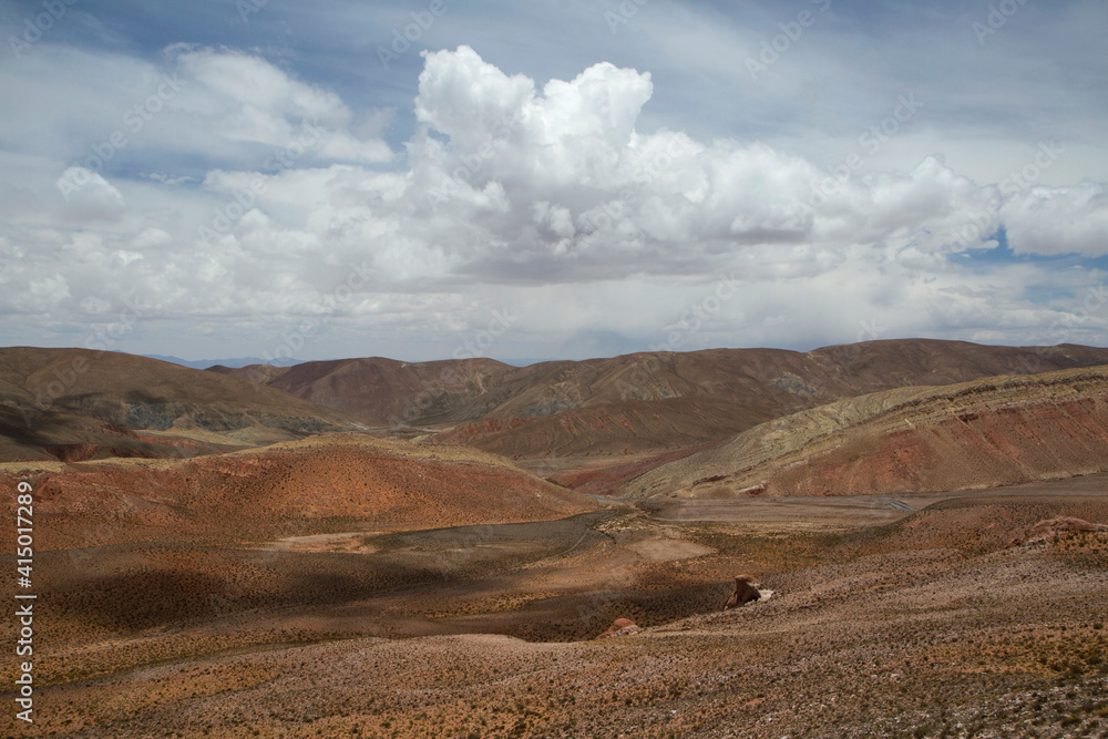The Andes mountain range. View of the arid valley, meadow, colorful dunes and hills under a beautiful sky. 
