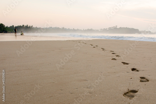 Two men watching the sunrise on Talalla beach, Sri Lanka photo