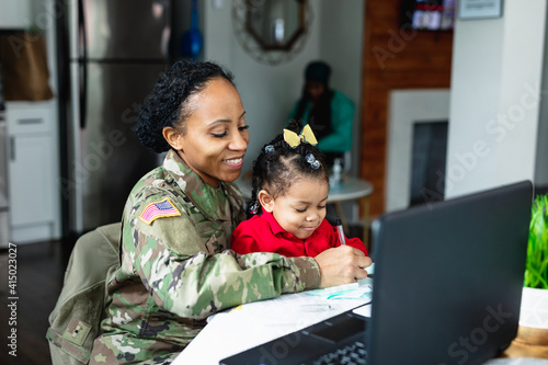 Military mom and daughter at home working photo