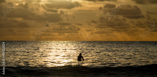 Wallpaper Mural Silhouette of man in sea during sunset at Freshwater West, Pembrokeshire, UK Torontodigital.ca