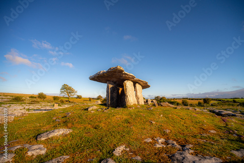 Poulnabrone dolmen on landscape against clear blue sky during sunny day at Clare, Ireland
