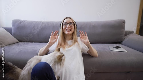 Attractive young woman speaking on camera, gesturing while have a cat neaby photo