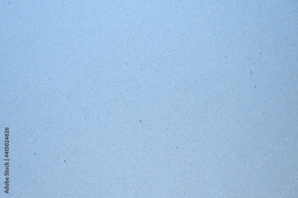 A sheet of gray-blue cardboard interspersed with various particles of paper. A sheet of gray-blue cardboard interspersed with various particles of paper.