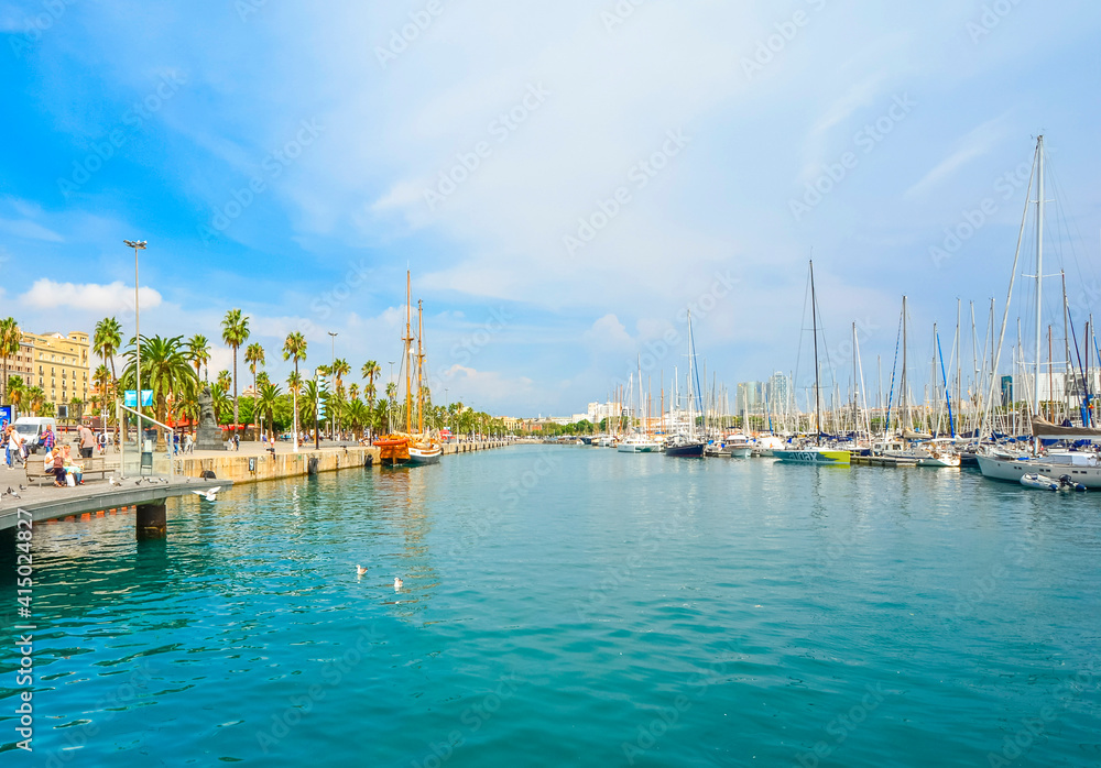 Summer along the port and marina with yachts in the water of the Mediterranean Sea in Barcelona, Spain.
