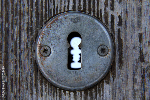 Keyhole and old door lock detail with wood background. 