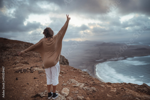 Young tourist girl visiting the Famara viewpoint in lanzarore, spain photo