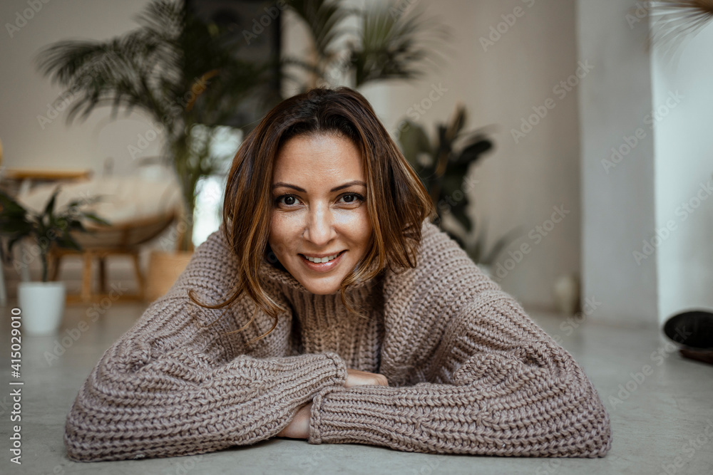 Smiling mature woman lying on front at home Smiling mature woman lying on front at home