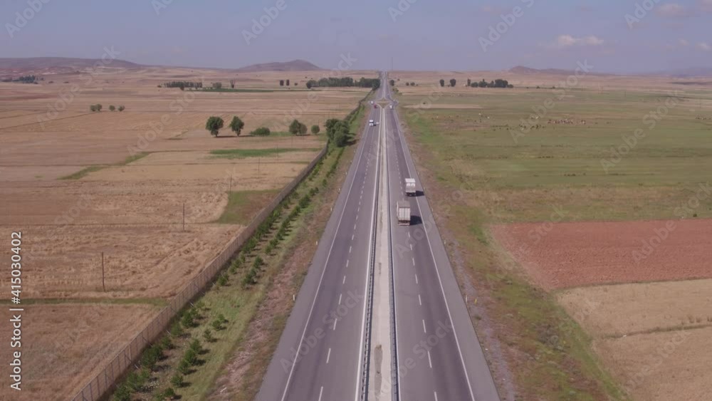 Semi truck alone driving on highway. White truck with trailer fast driving on bend autobahn among arid countryside flat dry landscape at summer sunny day, Aerial drone wide view Semi truck alone driving on highway. White truck with trailer fast driving on bend autobahn among arid countryside flat dry landscape at summer sunny day, Aerial drone wide view