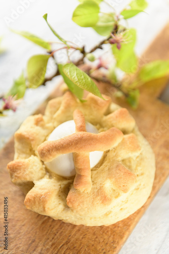 Taralli is a traditional Italian snack food typical of Puglia regional cuisine. Homemade sweet tarallini is in wooden cutten board with spring twig