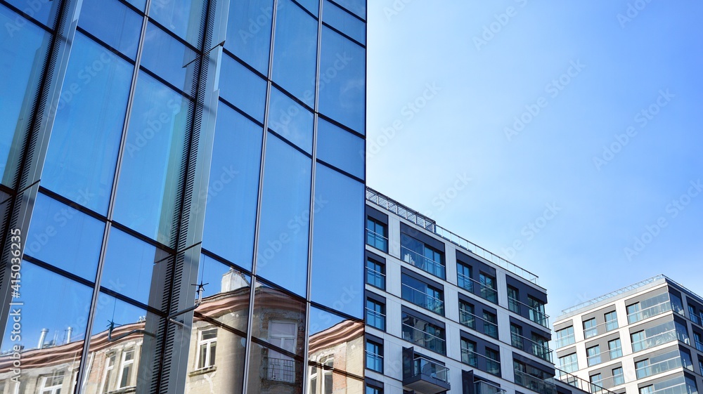 Facade texture of a glass mirrored office building. A beautiful background of an glass office building, reflecting clouds in the windows. Facade texture of a glass mirrored office building. A beautiful background of an glass office building, reflecting clouds in the windows.