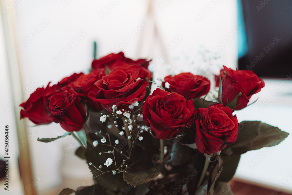 Obraz premium Red roses with white flowers in a vase - home decoration