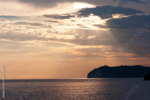 Picturesque beginning of the sunset over the promontory. Sunshine  sunray.