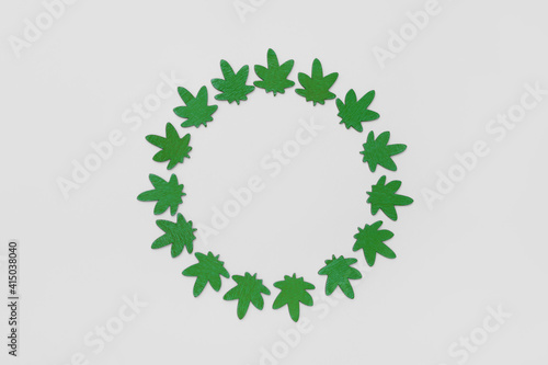 Marijuana leaves circle on gray background. Circle made from green cannabis leaves. Cannabis circle on gray background.