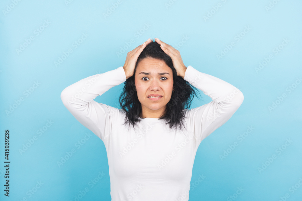 Young brunette woman laments with her hands on her head Young brunette woman laments with her hands on her head