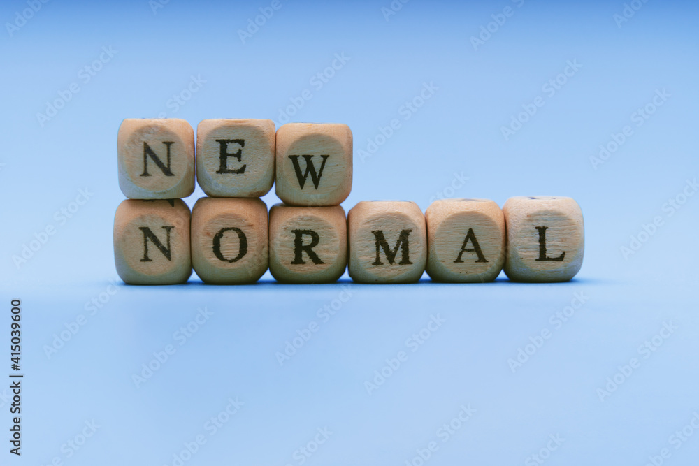 New Normal. Text on Wooden Block Against Blue Background. New Normal. Text on Wooden Block Against Blue Background.
