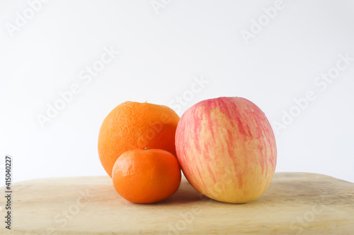 Oranges and Apple on the wooden table isolated on white background