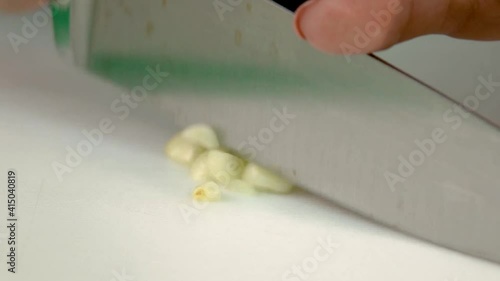 woman cuts garlic with knife 