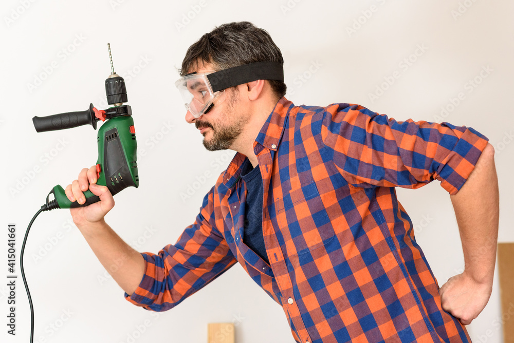 DIY enthusiast man holds a drill DIY enthusiast man holds a drill