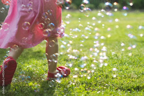 Little Girl Running Through Soap Bubbles