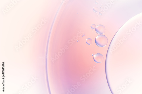 Closeup of abstract background with round shaped cells of vaccine of different sizes illuminated by colorful light