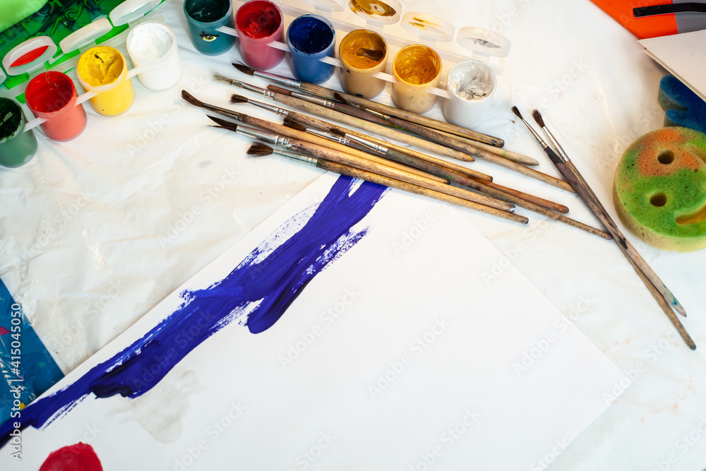 Brushes and paints on the table. Drawing with paints Brushes and paints on the table. Drawing with paints