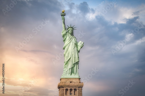 Statue of Liberty located on Liberty Island in New York against blue cloudy sky photo