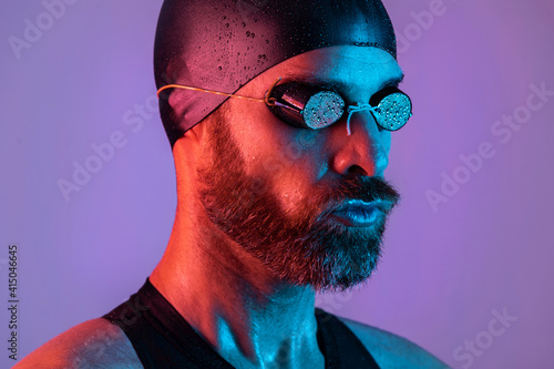 Side view studio portrait of a swimmer with cap and goggles photo