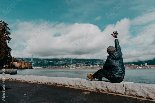 one man hands up in the air with lions gates bridge and clouds sky backgrounds photo