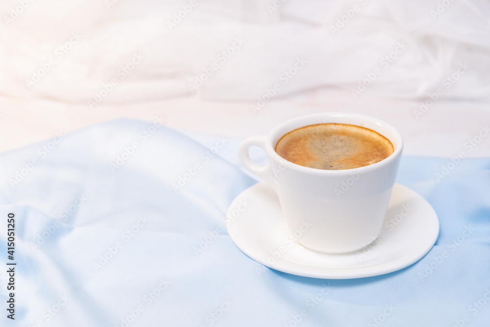 white cup of coffee on blue cloth white cup of coffee on blue cloth