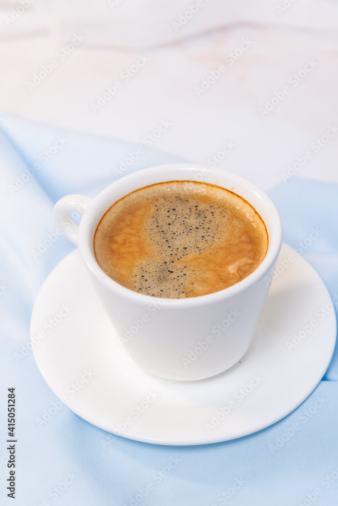 white cup of coffee on blue cloth white cup of coffee on blue cloth