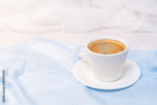 white cup of coffee on blue cloth