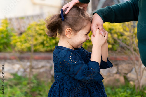 Little baby girl kiss her grandmother's hand during Eid mubarak (Turkish Ramazan or Seker Bayram). Adorable child kiss elderly woman hand to show respect. Cute toddler follow muslim Ramadan traditions