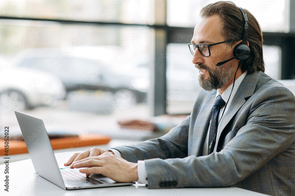 Concentrated middle aged businessman in headset is having a serious conversation, working on important project with colleagues. Focused male manager communicate with coworkers by video call Concentrated middle aged businessman in headset is having a serious conversation, working on important project with colleagues. Focused male manager communicate with coworkers by video call