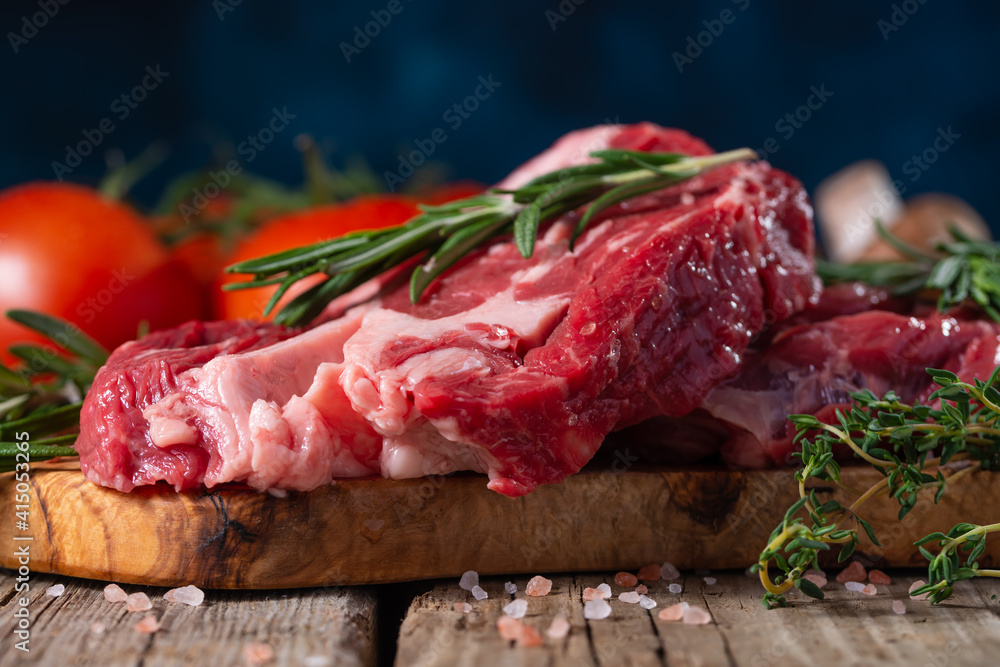 Fresh piece of beef steak with rosemary on the background of the ingredients.Recipe book, dishes with meat .Advertising butcher shops and meat markets banner
