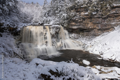 Blackwater Falls draped in Winter's white within Blackwater Falls State Park, West Virginia.