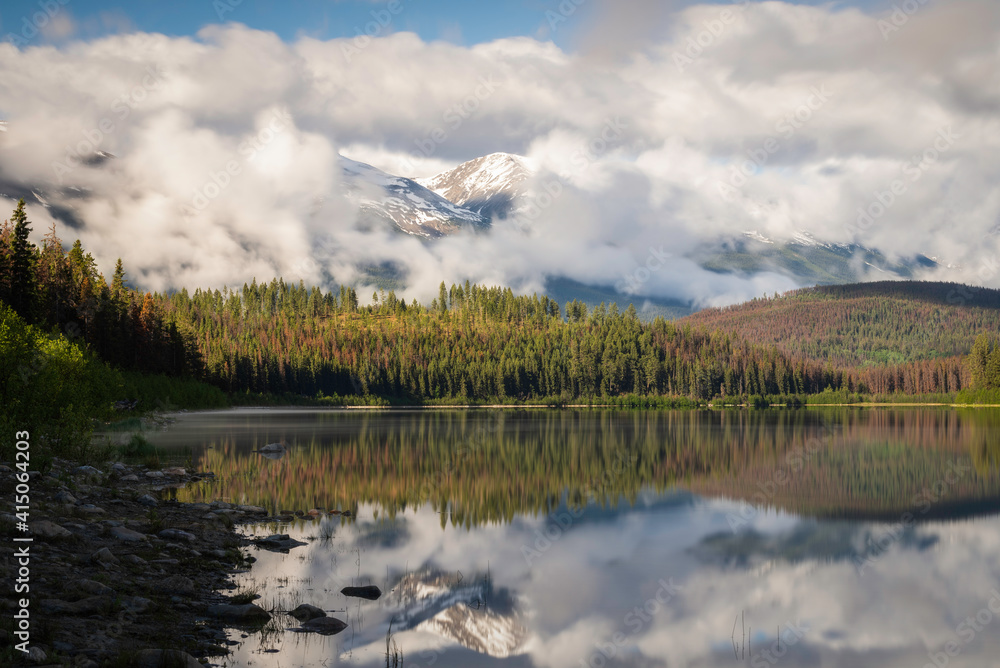 Fog rolling about the Canadian Rockies in Jasper National Park on a beautifully tranquil early Summer morning at Patricia Lake.