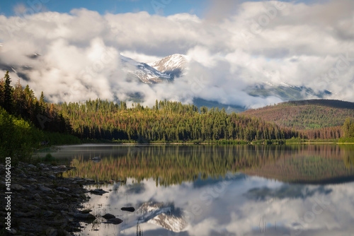 Fototapeta Naklejka Na Ścianę i Meble -  Fog rolling about the Canadian Rockies in Jasper National Park on a beautifully tranquil early Summer morning at Patricia Lake.
