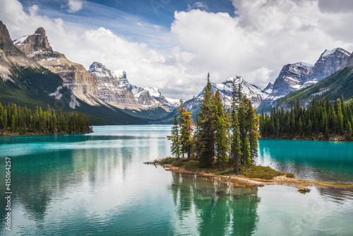 The famous Spirit Island of Maligne Lake in Jasper National Park of Alberta, Canada. Vivid blue-green waters of the glacially fed lake shine in the sunshine around the famous gathering of pines.